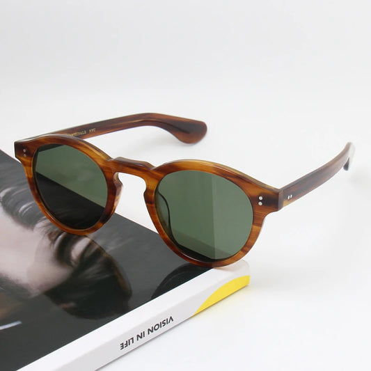 Sunglasses with tortoiseshell frame and dark lenses on a book with visible text.