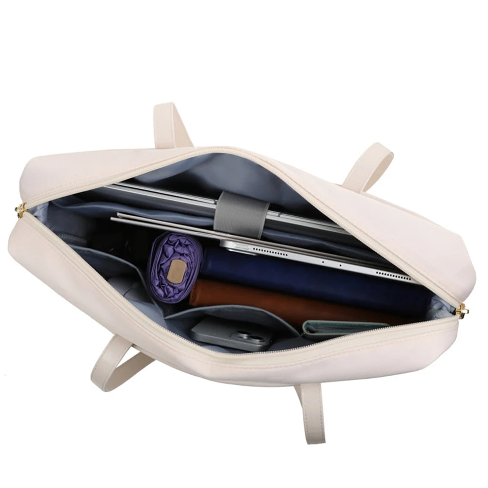 An open cream-colored laptop bag with a gray interior lining, shown with various tech accessories and a purple rolled item inside. The bag has a cream exterior, a gray interior, and gold-tone zipper pulls, photographed on a solid white background.