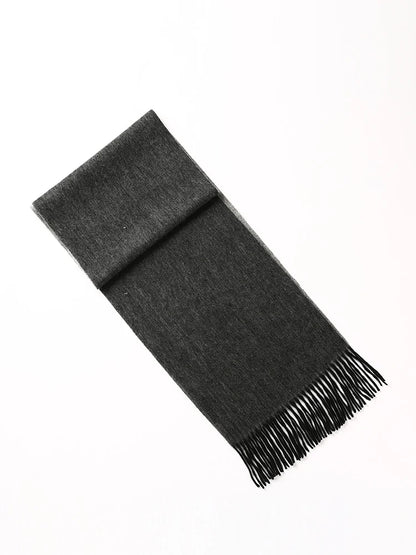 A dark charcoal gray knit scarf with fringed ends, folded neatly and presented diagonally on a clean white background.