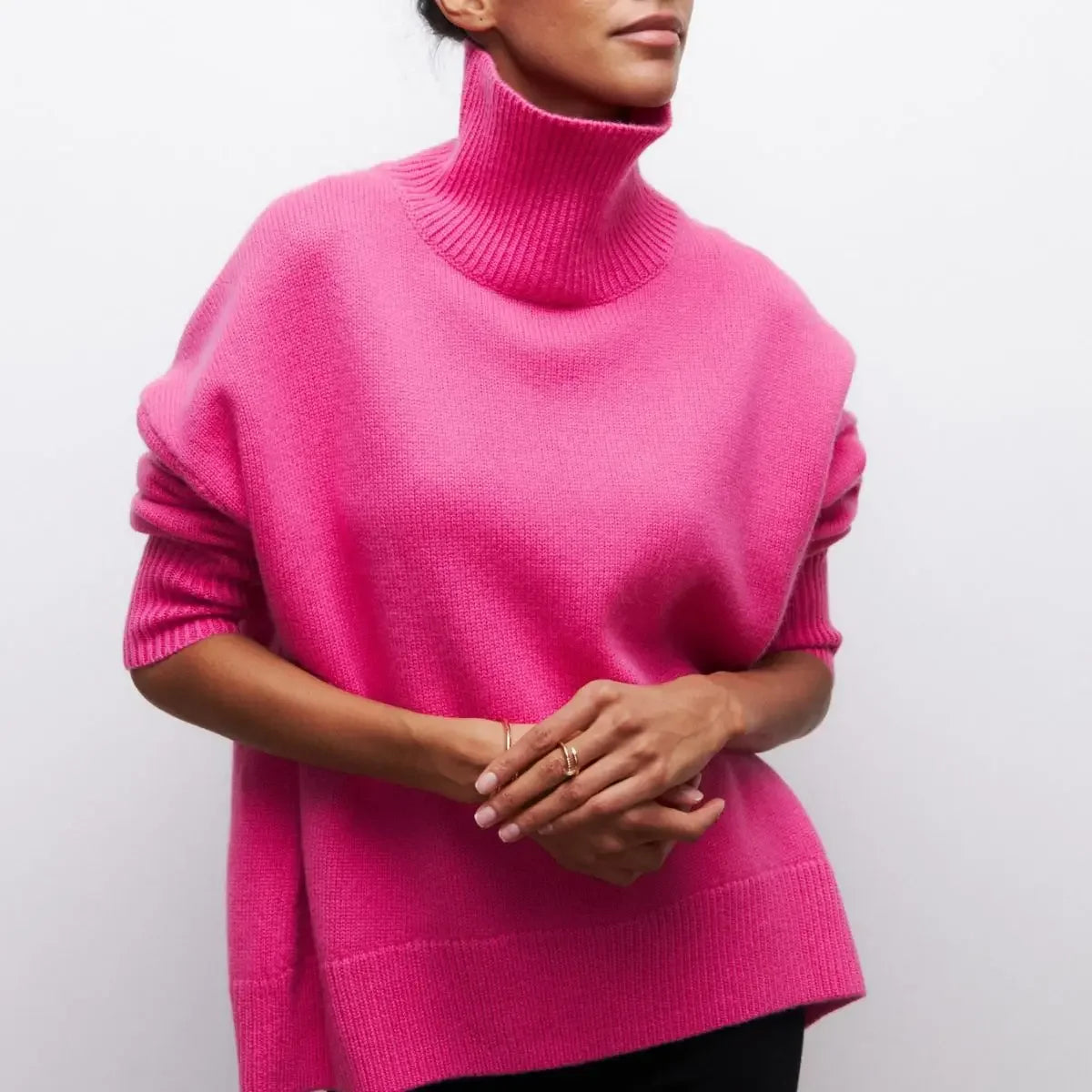 Person wearing a bright pink turtleneck sweater against a plain background
