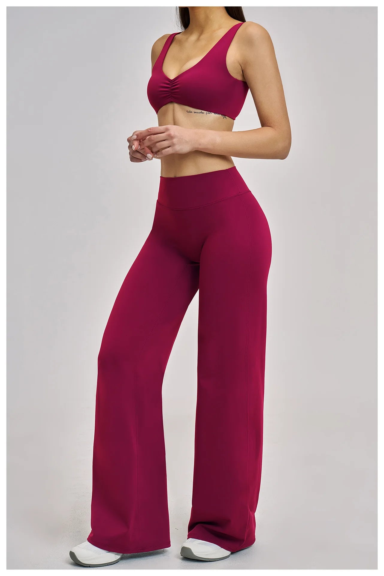 Person wearing a matching red sports bra and leggings set on a light gray background