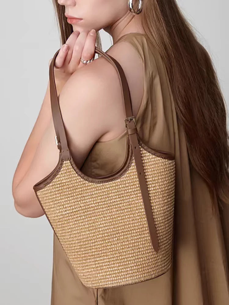 Woman holding a woven handbag with a plain background
