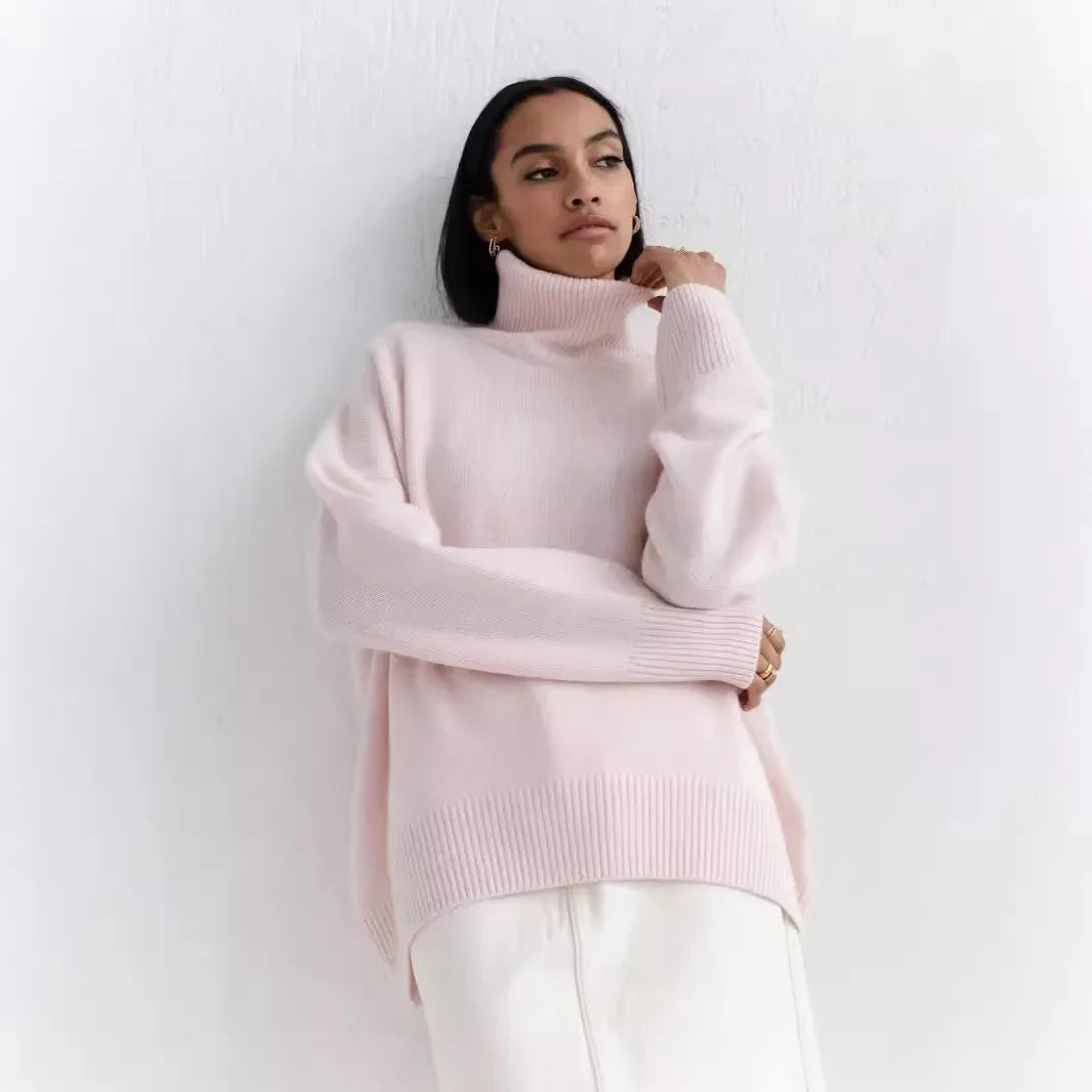 Person wearing a light pink turtleneck sweater against a white background