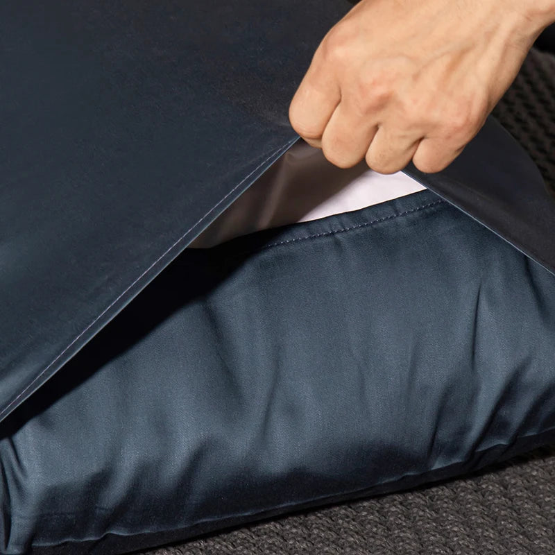 Person opening a navy blue garment bag with a white shirt inside.