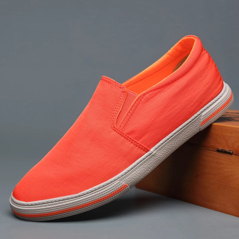 Orange slip-on shoe on a gray background