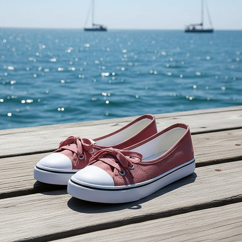 Pair of red sneakers with white soles on a wooden deck surface
