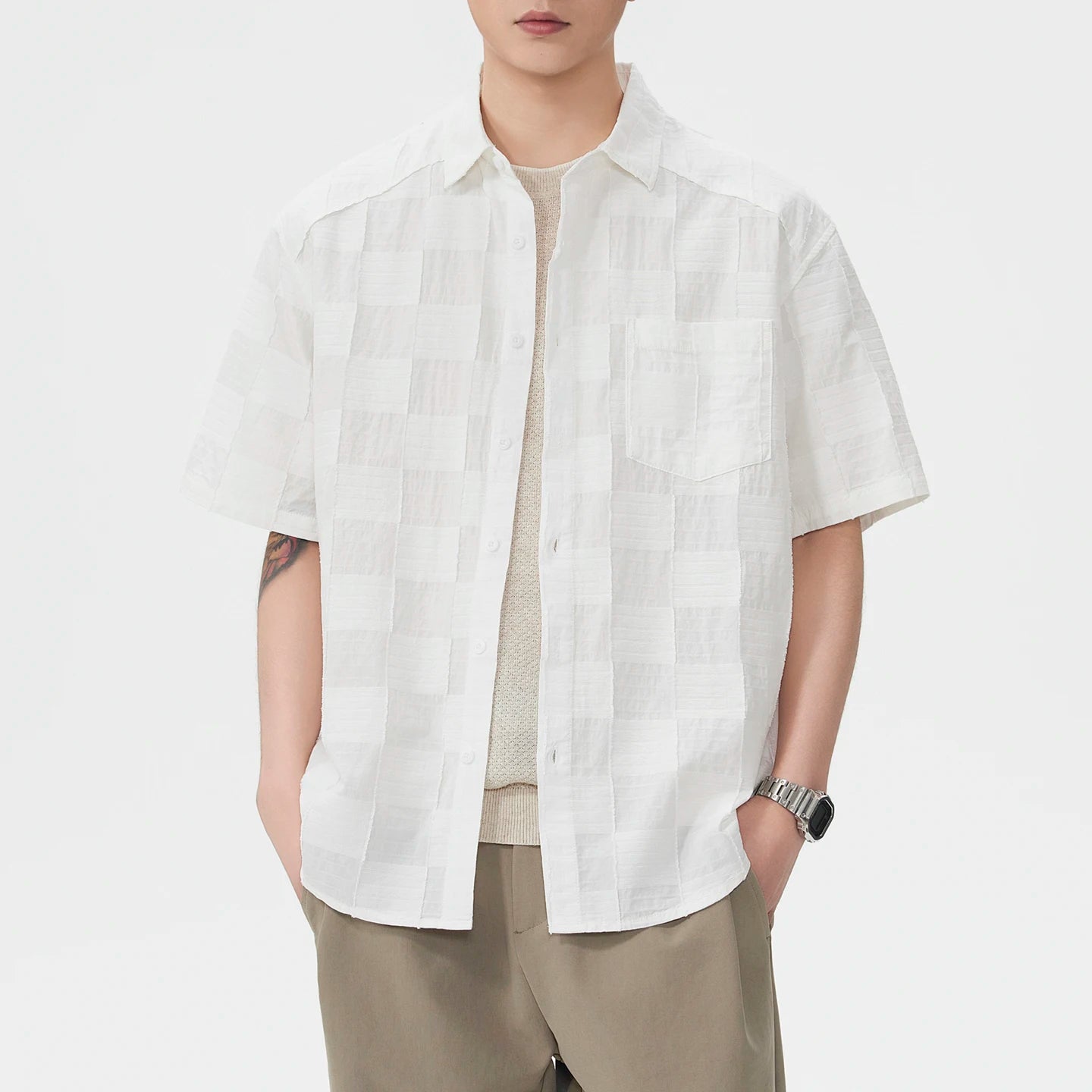 Person wearing a white short-sleeve shirt on a plain background