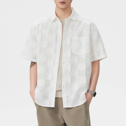 Person wearing a white short-sleeve shirt on a plain background