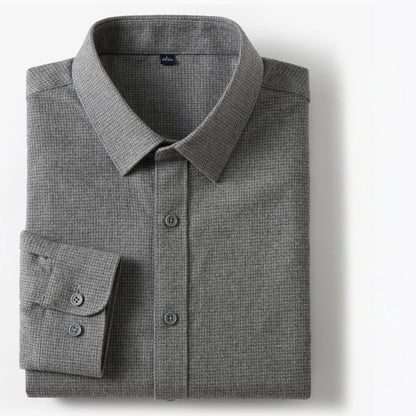 A folded gray textured long-sleeve dress shirt with a button-down front and a single cuff, shown on a clean white background.