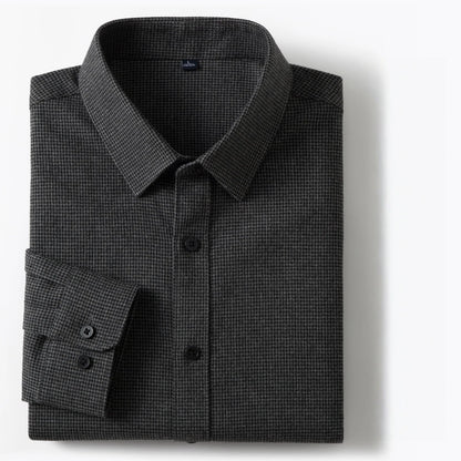 A folded dark gray micro-check patterned dress shirt with a pointed collar and button-down front, displayed on a clean white background.