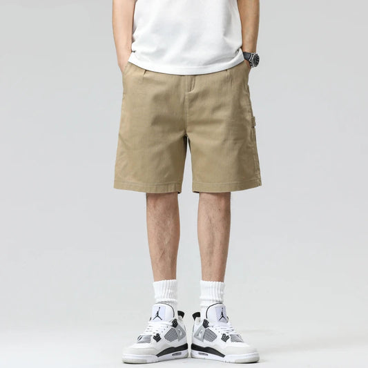 Person wearing beige shorts and white sneakers on a gray background with 'HIQOR' branding.