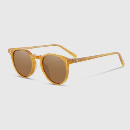 Yellow sunglasses with brown lenses on a light gray background
