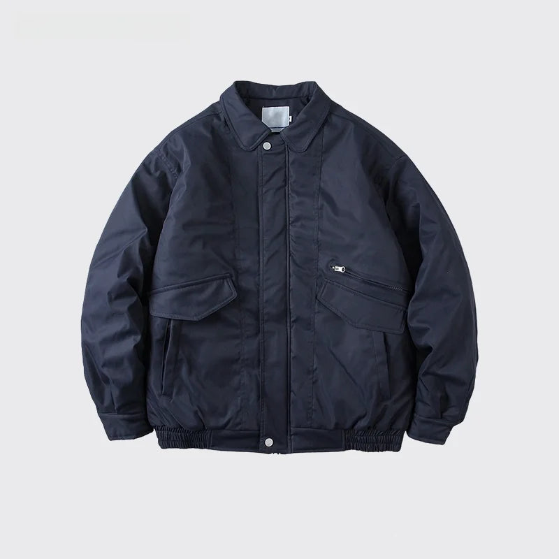 A dark navy blue bomber jacket with a stand collar, front snap closure, and zippered chest pocket, displayed against a light gray background with text below.