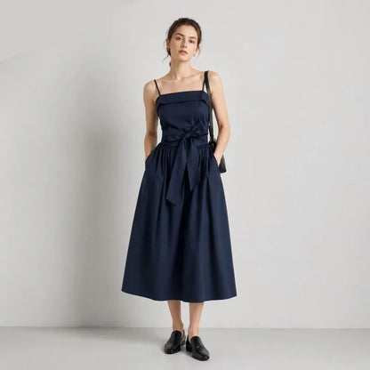 Woman wearing a navy blue dress with a belt on a light gray background, featuring the SEMIR brand.