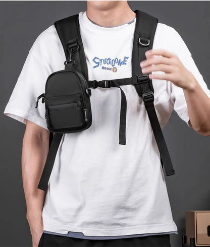 Person wearing a black crossbody bag over a white t-shirt with blue text.