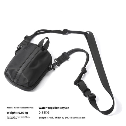Black water-repellent nylon bag with strap on a white background