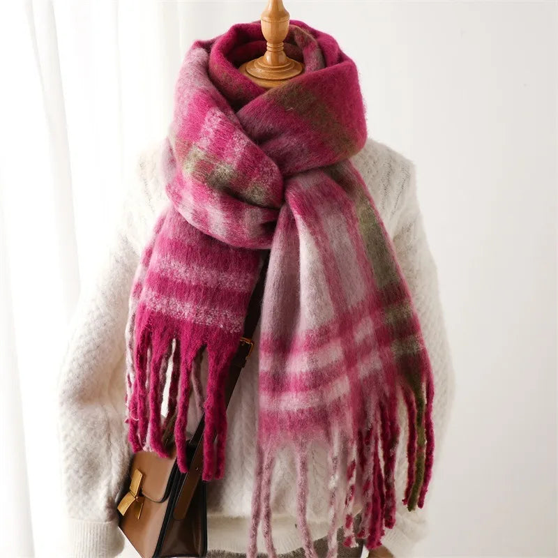 Pink plaid scarf with tassels draped over a mannequin against a white background