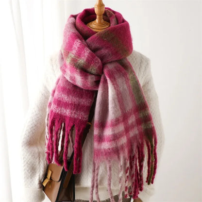 Pink plaid scarf with tassels draped over a mannequin against a white background