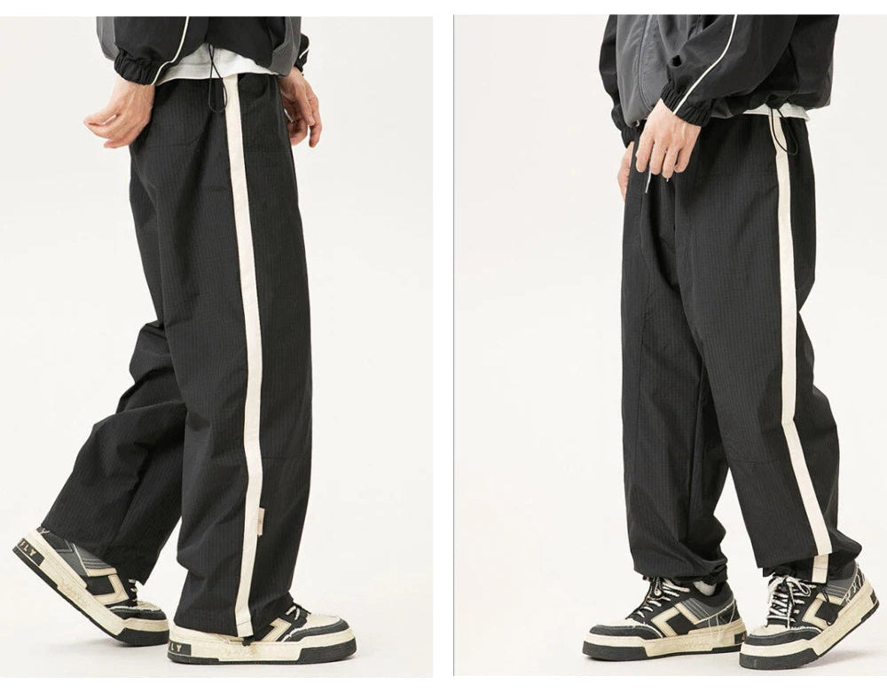 Gray pants with white stripes worn by a person on a white background