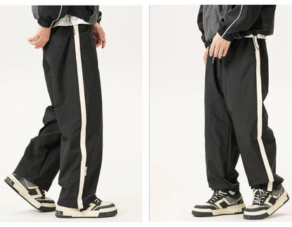 Gray pants with white stripes worn by a person on a white background