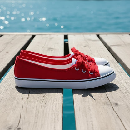 Red canvas shoes with white soles on a gray surface