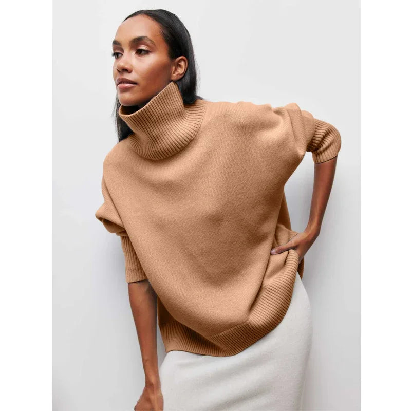 Woman wearing a beige turtleneck sweater against a white background