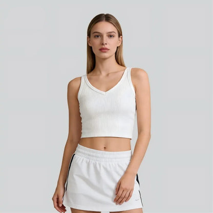Woman wearing a white tank top and skirt with SEM/R branding on a gray background