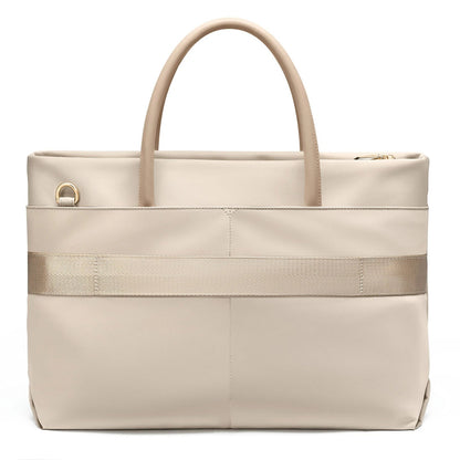A light beige GOLF tote bag with dual top handles, a horizontal textured stripe across the middle, and a gold-tone D-ring detail on the front left, shown on a white background.