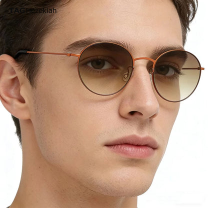 Close-up of a person wearing round sunglasses with a neutral background