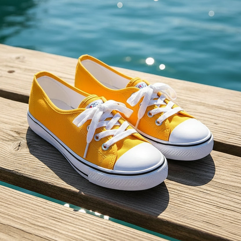 Yellow sneakers with white soles on a gray background