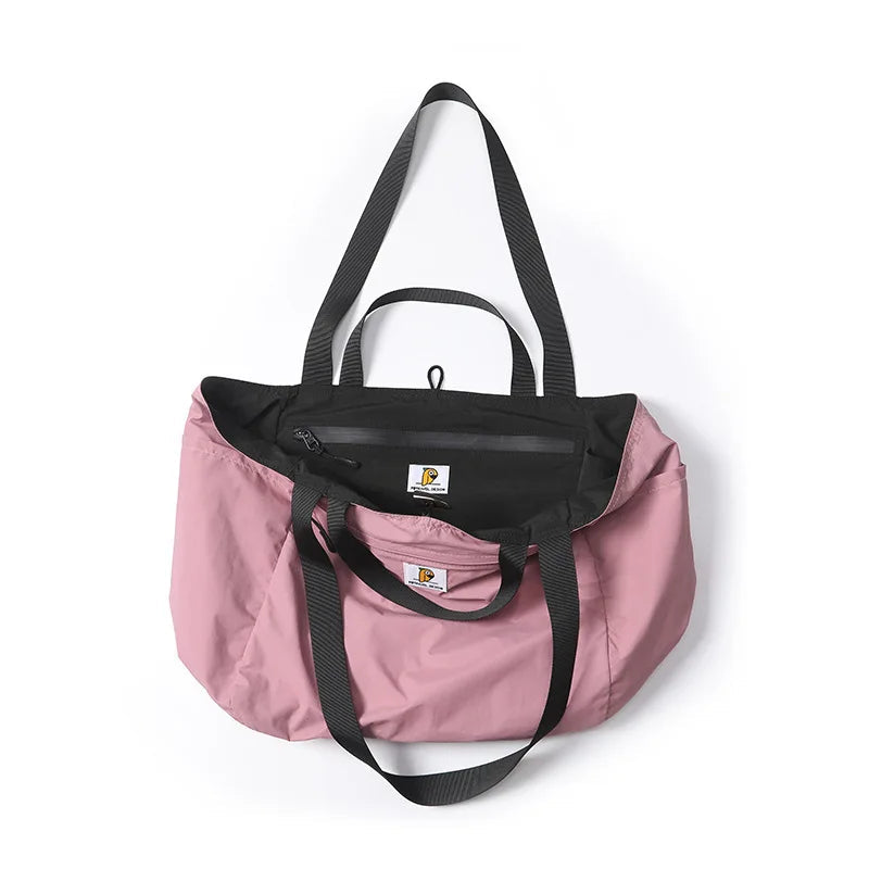 Pink tote bag with black accents on a white background, featuring the brand 'P.Travel'.