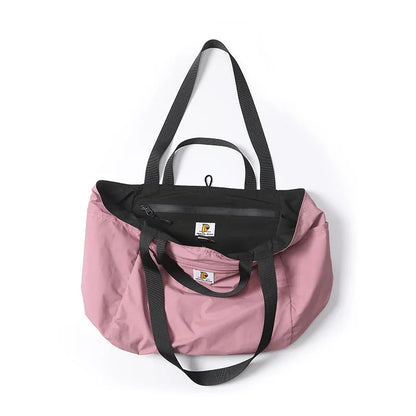 Pink tote bag with black accents on a white background, featuring the brand 'P.Travel'.