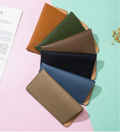 Set of leather wallets in various colors on a pink and green background