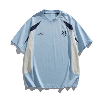 Light blue and beige t-shirt with brand logos on a white background