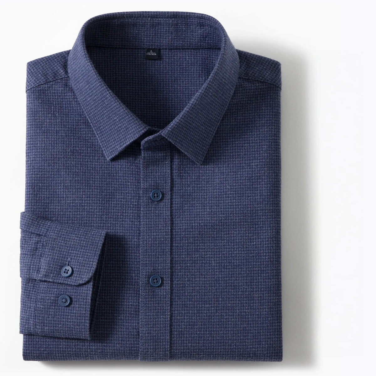 A folded navy blue long-sleeve dress shirt with a subtle textured waffle or micro-check pattern, featuring a classic collar, button-down front, and a single cuff with two buttons, shown on a clean white background.