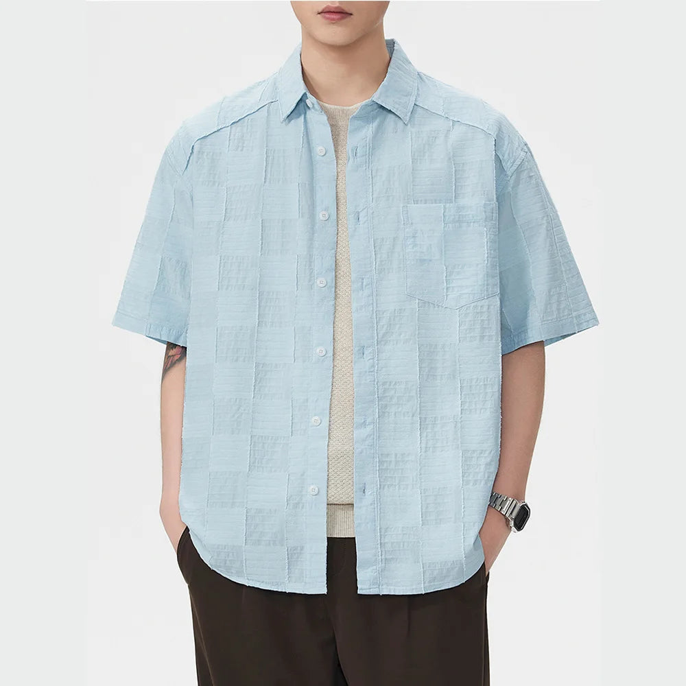 Person wearing a light blue short-sleeve shirt on a white background