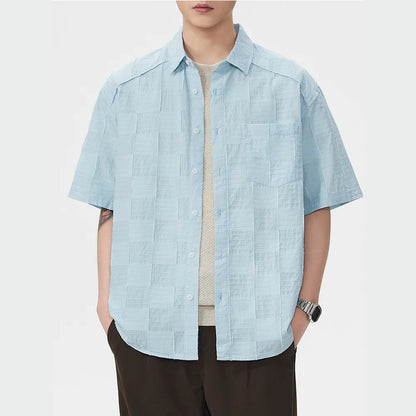 Person wearing a light blue short-sleeve shirt on a white background