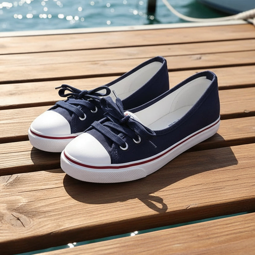Navy blue sneakers with white soles on a wood deck surface
