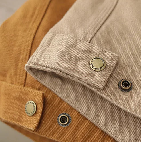 Close-up of a beige jacket with button details on a neutral background