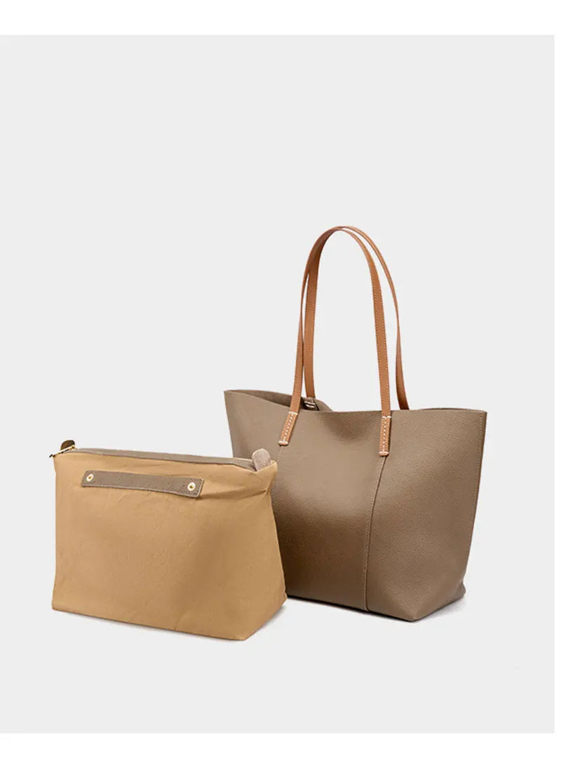 Two beige handbags, a larger tote and a smaller pouch, on a white background.