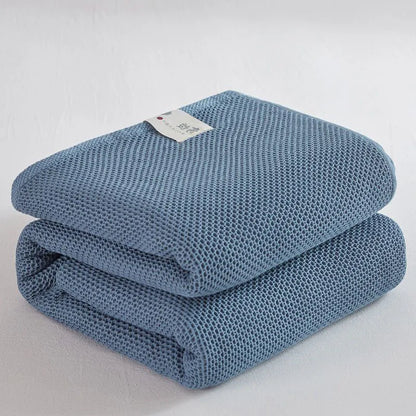 Folded blue textured blanket on a light gray background
