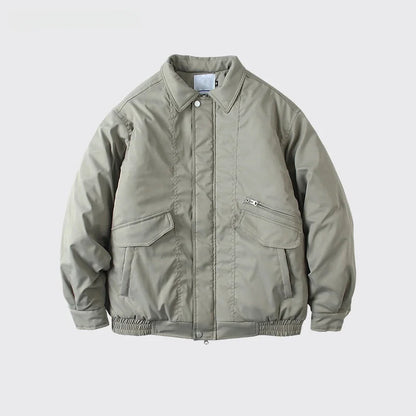 A light olive green utility jacket with a button-up front, collar, and zippered chest pocket, displayed on a light gray background with text below.
